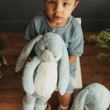 Load image into Gallery viewer, Little Floppy Nibble loves BIG hugs. With long lop buttery soft ears for soothing and hand-embroidered face, pink cheeks and big fluffy tail this stuffed bunny is made to be loved.

This stuffed animal has sweet Maui Blue and warm white fur and velour-lined ears perfect for personalizing. This is sure to be a favorite stuffed bunny for wee ones and adults alike with its heirloom quality and timeless appeal.
