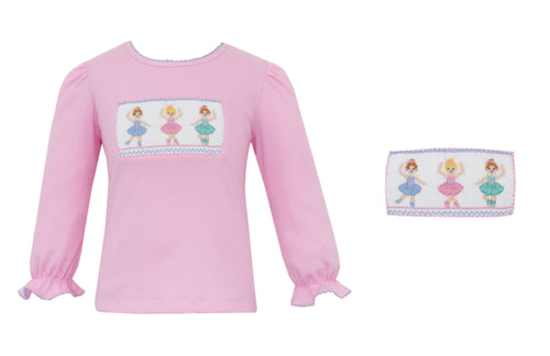 Introducing our Ballet Dancer Knit Tunic for Girls. Made with soft cotton material and featuring a delicate ruffle detail, this shirt is perfect for your little dancer. The smocked ballet design adds a touch of elegance to any outfit. Perfect for playtime or as a stylish addition to any wardrobe.