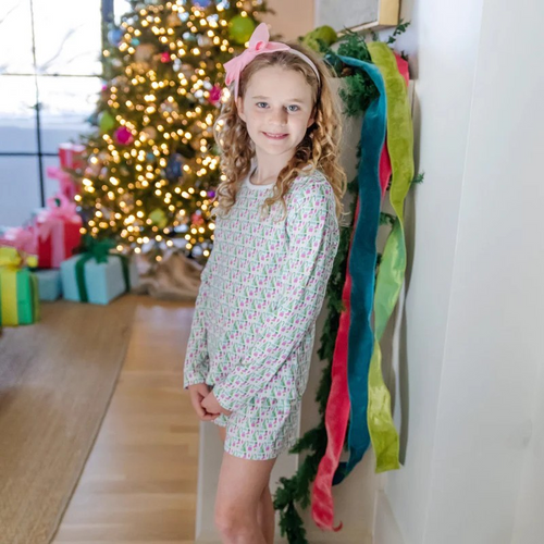 Keep her cozy and stylish this holiday with the Sophie Girls' Lounge Short Set in Mod Holiday Pink by Lila & Hayes. This two-piece set features a long-sleeve top paired with comfortable shorts, designed for relaxed yet vibrant loungewear. The fun retro-inspired print adds a playful touch, making it perfect for festive gatherings or cozy days at home. Let her shine this season with a look that’s as cheerful as it is comfortable.