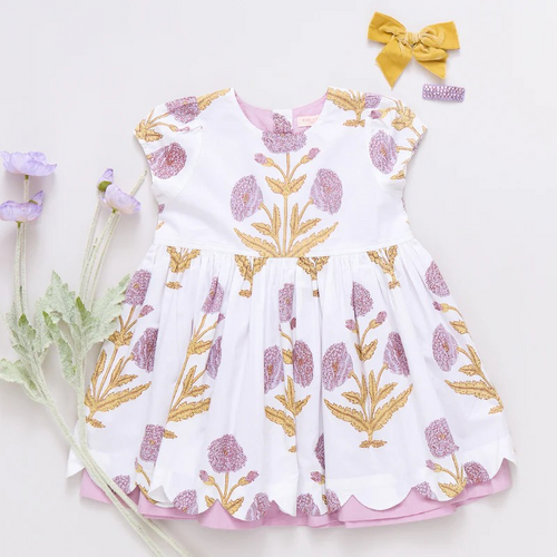 Peek A Boo! Oversized wild dandelions bloom against a 100% cotton vintage cotton voile on our extra special Girls Marisol Dress. Full of surprises, this short sleeve vintage-inspired piece has a purple lining peeking out from behind the scalloped hem and a set of sparkly glitter buttons at the back. 