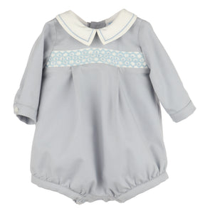 Crafted for timeless charm, this Infant Boys Dusty Blue Smocked Bubble features a classic Peter Pan collar with delicate embroidered borders. The front showcases hand-smocked embroidery, adding a refined touch perfect for special occasions or memorable photo milestones.