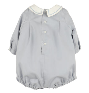 Crafted for timeless charm, this Infant Boys Dusty Blue Smocked Bubble features a classic Peter Pan collar with delicate embroidered borders. The front showcases hand-smocked embroidery, adding a refined touch perfect for special occasions or memorable photo milestones.
