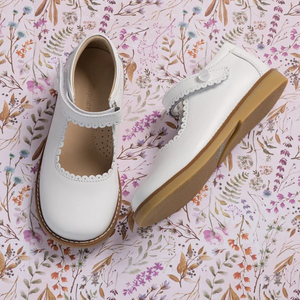 The Elephantito Classic Mary Janes combine style and functionality with supported ankles and scalloped edges. Handcrafted from premium leather, these shoes offer durability and quality. The natural sheepskin lining provides softness, protection, and absorption. Lightweight and flexible rubber soles ensure ample support and grip. Recycled leather insoles with Bontex cushioning add extra comfort. Reinforced heel and toe protect growing feet. The hook-and-loop closure ensures a perfect fit and easy wear.

Clas