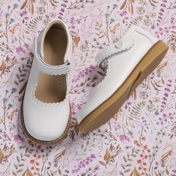 The Elephantito Classic Mary Janes combine style and functionality with supported ankles and scalloped edges. Handcrafted from premium leather, these shoes offer durability and quality. The natural sheepskin lining provides softness, protection, and absorption. Lightweight and flexible rubber soles ensure ample support and grip. Recycled leather insoles with Bontex cushioning add extra comfort. Reinforced heel and toe protect growing feet. The hook-and-loop closure ensures a perfect fit and easy wear.

Clas