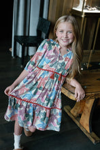 Load image into Gallery viewer, The Hattie Bow Dress by Briton Court dazzles with its elegant tiers and charming bow print, enhanced by rich red velvet accents. Designed for tween girls, it’s the perfect choice to celebrate every holiday moment with grace and festive style!
