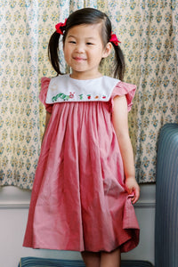 Celebrate your little reader’s style with the Girls Red Bookworm Dress from The Proper Peony. This charming dress features a delightful embroidered bookworm on the front and playful ruffle sleeves, all in a soft heathered red fabric. It’s the perfect back-to-school outfit that combines comfort and cuteness, making every day a storybook adventure for your little bookworm.