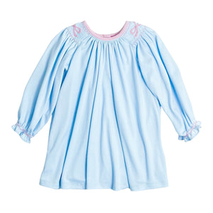 This toddler Girl's Juno Bow Dress in soft light blue combines charming details with comfort. Featuring delicate smocking and a hand-embroidered bow detail adds a touch of elegance to your little one’s wardrobe. Crafted for softness and ease, it ensures your girl stays comfortable while looking irresistibly sweet.
