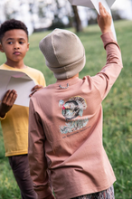 Load image into Gallery viewer, Classic long-sleeve comfort with a playful twist. This boys' tee features a turkey graphic on the back in warm burnt orange, paired with a functional front pocket for everyday wear. Soft cotton construction keeps him comfortable all day long, whether heading to school or weekend adventures. Perfect for fall layering or standalone wear.
