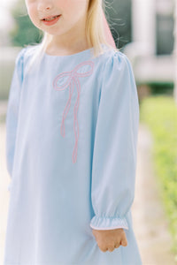 The Brooklyn Bow Dress from The Proper Peony offers timeless elegance with its classic A-line silhouette and delicate embroidered bow detail. Perfectly blending style and simplicity, this dress captures the charming bow trend for little girls, making it an ideal choice for special occasions or everyday wear. Its refined design ensures your child looks effortlessly stylish and comfortable all day long.