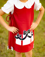 Load image into Gallery viewer, Girls Presents Emma Dress from The Yellow Lamb. Features a red jumper with applique plaid presents on each side. Fun &amp; playful way to celebrate the holidays. Pair with a peter pan shirt and tights for a pulled together look.&nbsp;
