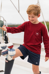 This Boys Harbor Boats Graphic Tee from Saltwater Boys combines comfort and style in a long-sleeve burgundy design perfect for toddlers to tweens. Crafted from soft knit fabric, it features an nautical harbor scene on the back along with a classic SWB logo and pocket on the front, making it an ideal choice for everyday wear or a casual outing. Durable and fashion-forward, this tee ensures your young one looks sharp while staying comfortable throughout the day.