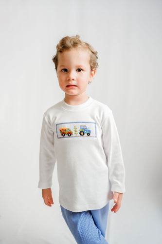 Introduce your little one to timeless charm with this Boys Harvest Farm Smocked Harry's Play Tee. Crafted from soft white knit fabric, this long-sleeve essential features an enchanting smocked and hand-embroidered farm scene that captures childhood wonder. The meticulous artisanal details make it a standout piece perfect for playdates, family gatherings, or everyday wear. 