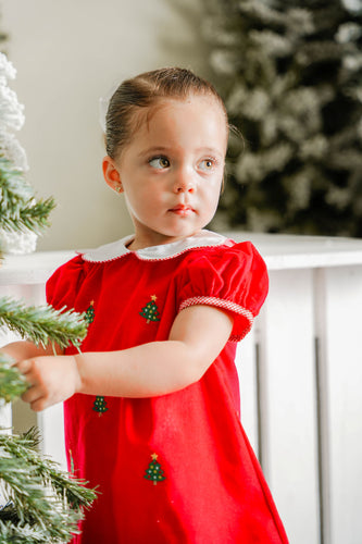 Celebrate the season in style with the Girls Christmas Tree Kendall Dress from Zuccini Kids. This charming red corduroy dress is adorned with festive Christmas Tree embroidery and accented with classic red and white gingham details. Featuring a delicate Peter Pan collar and scalloped hem, it’s the perfect holiday outfit for your little one to shine and coordinate beautifully with sibling looks. Embrace timeless holiday cheer and create lasting memories in this delightful dress.