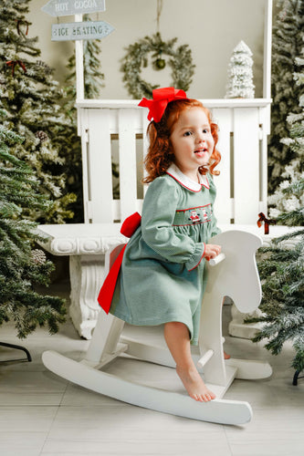 This charming Girls Marion Santa Claus Smocked Stripe Dress combines festive spirit with timeless style. Crafted from soft knit fabric in green and white stripes, it features a delicate Peter Pan collar and exquisite hand-embroidered dancing Santas across the smocked bodice. A classic red bow tie at the back adds a perfect finishing touch, making it an ideal choice for joyful holiday celebrations and memorable photos. Comfortable and adorable, this dress will make your little one shine throughout the season