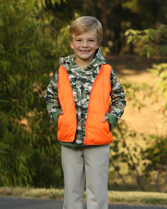 Stay ready for fall adventures with the Boys Delta Valley Vest from The Yellow Lamb. This reversible vest features vibrant orange on one side and woodland camo on the other, offering versatile style for boys who love the outdoors. Lightweight yet warm, it’s perfect for layering during crisp autumn days, keeping your little one comfortable and visible on every trail. Durable and easy to wear, this vest combines practicality with fun, making it an essential piece for active boys this season.