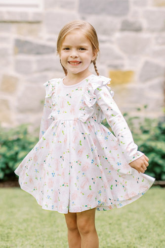 The Girls En Pointe Twirl Dress from The Proper Peony features a soft knit fabric adorned with an elegant ballet and bow print. Its charming ruffle detail and flowy design invite endless twirling, making it perfect for a day filled with dance and delight. Comfortable and stylish, this dress is sure to inspire her graceful moves and joyful moments.