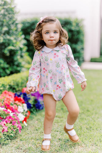 The English Garden Long Sleeve Bubble from The Proper Peony combines comfort and charm with its soft knit fabric and vibrant pastel floral print on a gentle pink background. Featuring a delicate scalloped white collar, this bubble romper adds a touch of casual elegance to your infant girl's wardrobe, perfect for everyday wear or special occasions.