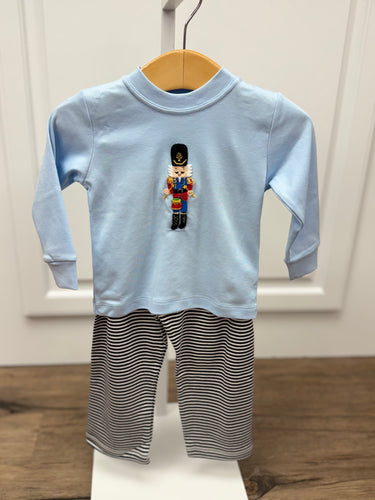 Get your little one holiday-ready with the Boys Nutcracker & Striped Pant Set from Squiggles. This charming ensemble features a light blue long-sleeve tee adorned with a festive Nutcracker applique, paired with coordinating navy and white striped knit pants. Perfectly combining seasonal style with all-day comfort, this set is ideal for family gatherings, holiday photos, or everyday festive fun. Keep your boy cozy and stylish throughout the season with this must-have holiday outfit.