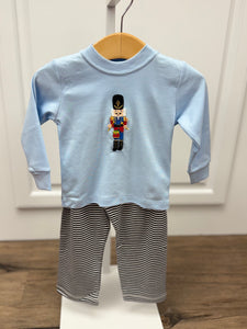 Get your little one holiday-ready with the Boys Nutcracker &amp; Striped Pant Set from Squiggles. This charming ensemble features a light blue long-sleeve tee adorned with a festive Nutcracker applique, paired with coordinating navy and white striped knit pants. Perfectly combining seasonal style with all-day comfort, this set is ideal for family gatherings, holiday photos, or everyday festive fun. Keep your boy cozy and stylish throughout the season with this must-have holiday outfit.