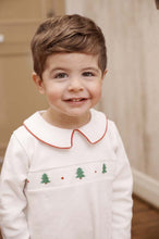 Load image into Gallery viewer, The Samuel Smocked Romper by The Beaufort Bonnet Company wraps your little one in festive charm with hand-smocked Christmas trees and a classic Peter Pan collar edged in red. Crafted from heavyweight white fabric, it’s perfect for unforgettable holiday moments.
