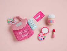 Load image into Gallery viewer, The life-like toys in Mud Pie’s My First Purse set will have your child pretending to be Mommy. The 7-piece set comes with a plush play purse. The purse comes with six familiar accessories: baby safe mirror, set of keys, make-up compact, credit card, plush lipstick, coffee cup with rattle and plush phone with ringing sound effect.
