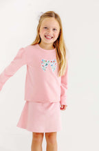 Load image into Gallery viewer, The Fair St Floral Bow Cassidy Comfy Crewneck by The Beaufort Bonnet Company combines cozy warmth with charming style. Its soft pink fabric, puff sleeves, and delicate floral bow create a timeless look perfect for tween girls’ school days and casual outings in cooler weather.
