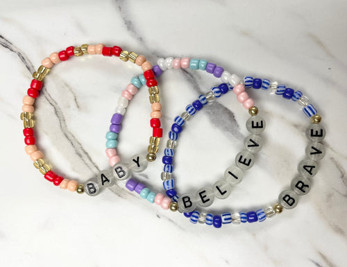 Show your confidence with these Swiftie inspired friendship bracelets! Each one features inspiring words and fun glow in the dark beads for extra fun. Plus, with proceeds going to charity, you can make a positive impact while expressing yourself. Made by Anuja Tolia.