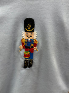 Get your little one holiday-ready with the Boys Nutcracker &amp; Striped Pant Set from Squiggles. This charming ensemble features a light blue long-sleeve tee adorned with a festive Nutcracker applique, paired with coordinating navy and white striped knit pants. Perfectly combining seasonal style with all-day comfort, this set is ideal for family gatherings, holiday photos, or everyday festive fun. Keep your boy cozy and stylish throughout the season with this must-have holiday outfit.