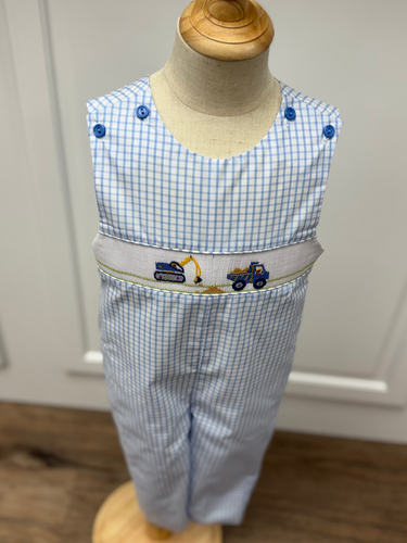 This Boys Construction Site Longall showcases a charming blue and white gingham pattern, highlighted by a detailed smocked construction site embroidery on the front. Designed for comfort and style, it pairs perfectly with a classic Peter Pan collar shirt, creating an adorable and polished outfit ideal for playful days and special occasions.