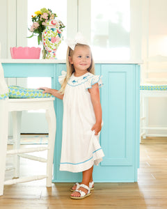 Elevate your little one's beach style with our White Marlin Smocked Bishop Dress. Made from crisp white pique fabric, this dress features a smocked neckline, flutter sleeves, and vibrant blue marlin embroidery. Perfect for any beach day, it's a must-have for your toddler's wardrobe!