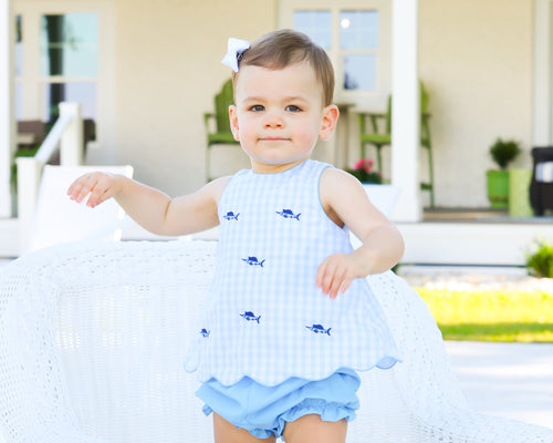 Dress up your little one in our Blue Marlin Scalloped Bloomer Set by Cape Point Clothing Co. This adorable set features a fun blue check pattern and intricate blue marlin fish embroidery. With a scalloped hem and asymmetrical back opening, it's a unique and stylish addition to any baby's wardrobe. Complete the look with the included blue ruffle bloomers.