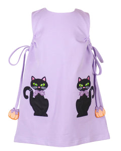 The Emma Jumper Black Cats from The Yellow Lamb is a charming lavender shift dress perfect for your toddler’s Halloween celebrations. Featuring playful black cat appliques, this jumper combines festive fun with classic style, making it an ideal choice for little girls to enjoy the season in comfort and cuteness. Pairs with The Yellow Lamb matching Lavender Leggings so she can wear this as a dress or a set on cooler days!