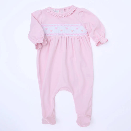 Celebrate love with our Valentine’s Classic Smocked Footie by Magnolia Baby! Made with soft pink Pima cotton and adorned with smocked hearts, this footie is both adorable and comfortable. Perfect for your little one to wear on Valentine’s Day or any day to spread some love and joy.