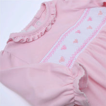 Load image into Gallery viewer, Celebrate love with our Valentine’s Classic Smocked Footie by Magnolia Baby! Made with soft pink Pima cotton and adorned with smocked hearts, this footie is both adorable and comfortable. Perfect for your little one to wear on Valentine’s Day or any day to spread some love and joy.
