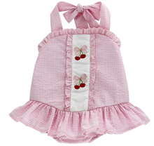 Load image into Gallery viewer, Experience the joyful spirit of summer with the Cherry Jubilee Bathing Suit by Bailey Boys! This delightful pink seersucker design, adorned with charming cherries, ensures your little one stands out at the beach or pool. The precious drop hem ruffle and halter tie neck add a touch of playful elegance, making every splash a memorable moment!
