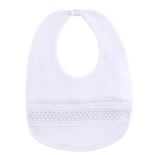 Load image into Gallery viewer, The Baby Smocked Bullion Bib by Feltman Brothers is a timeless accessory for your little one! This adorable baby bib matches perfectly with our Infant Smocked Bullion Gown and Hat and would be a perfect gift set! Perfect as a baby gift for your loved one, or as an heirloom piece to treasure forever! 

We carry the White/Blue and the White/Pink. The double pink bib in the lifestyle picture is not a color we carry, just a glimpse of this precious piece! 
