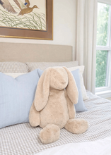 Load image into Gallery viewer, Mud Pie’s Theo The Bunny Large Taupe Plush Pal is a delightful companion designed to bring comfort and joy! Crafted from high-quality faux fur, this plush toy offers a luxuriously soft and cuddly texture, making it perfect for snuggling. The plush is thoughtfully designed with a weighted seat, hands, and feet, providing a comforting and reassuring feel when held. Standing at an impressive 22 inches tall, Theo The Bunny is an ideal size for hugging and carrying around.
