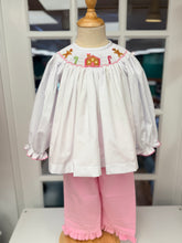 Load image into Gallery viewer, Cape Point Clothing Co.’s Gingerbread Cottage Bishop Pant Set delights with a charming white blouse accented in pink ruffles and whimsical gingerbread cottage smocking. Paired with cozy pink corduroy pants featuring ruffled hems, it keeps your toddler warm and radiant throughout the magical Christmas season!
