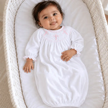Load image into Gallery viewer, Graceful and timeless, the Forever Blessed Bishop Gown is a beautiful choice for life’s most meaningful moments. Designed with classic bishop-style smocking around the neckline, it features delicate hand-smocked cross motifs in soft pink, adding a sweet and sentimental touch.

