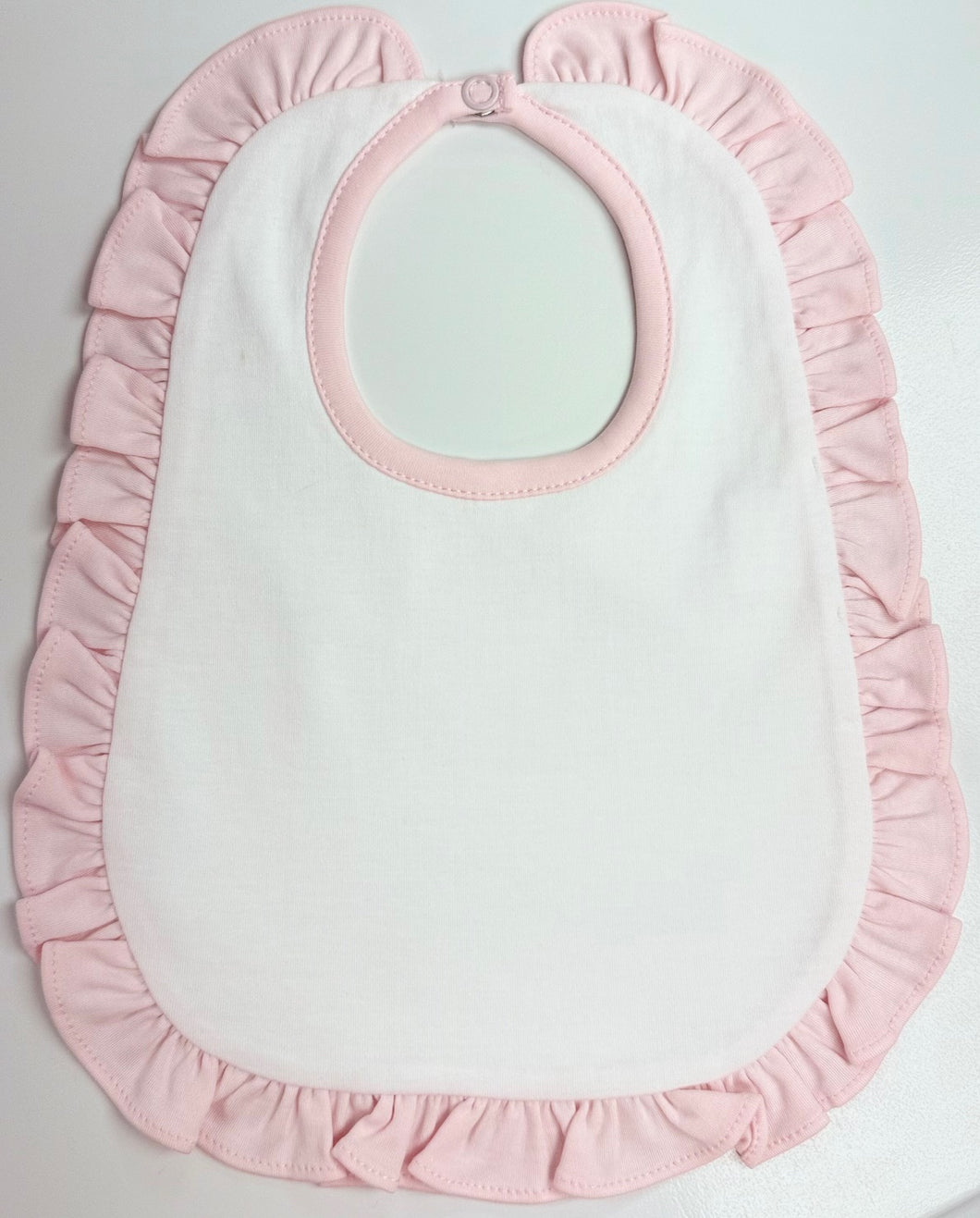 Infant White & Pink Ruffle Bib from Baby Loren features a white bib with pink ruffle. Perfect for a monogram!