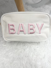 Load image into Gallery viewer, Cream canvas toiletry bag for baby features soft pink BABY embroidery on the front and gold zipper at top. Approx. dimensions: 10&quot; x 3&quot; x&nbsp; 6&quot;. Perfect for any travel bag or diaper bag essentials holder. Makes a great gift for new moms.&nbsp;
