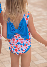 Load image into Gallery viewer, Celebrate the 4th of July in style with our Toddler Girls Lottie Patriotic Stars Swimsuit from James &amp; Lottie. Featuring a bold star print and a large blue bow in the back, your little one will feel confident and stylish while showing off her patriotic spirit.
