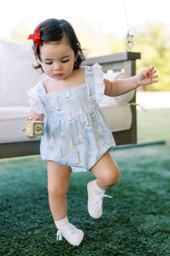 Introducing the Infant Girls Mariner Bubble from The Proper Peony! Made with 100% Pima cotton, this adorable bubble features a charming mariner motif in light blues and sailboat design. The ruffle shoulders and criss cross back add a touch of classic style. Perfect for your little one's coastal adventures. Order now and make a stylish statement!