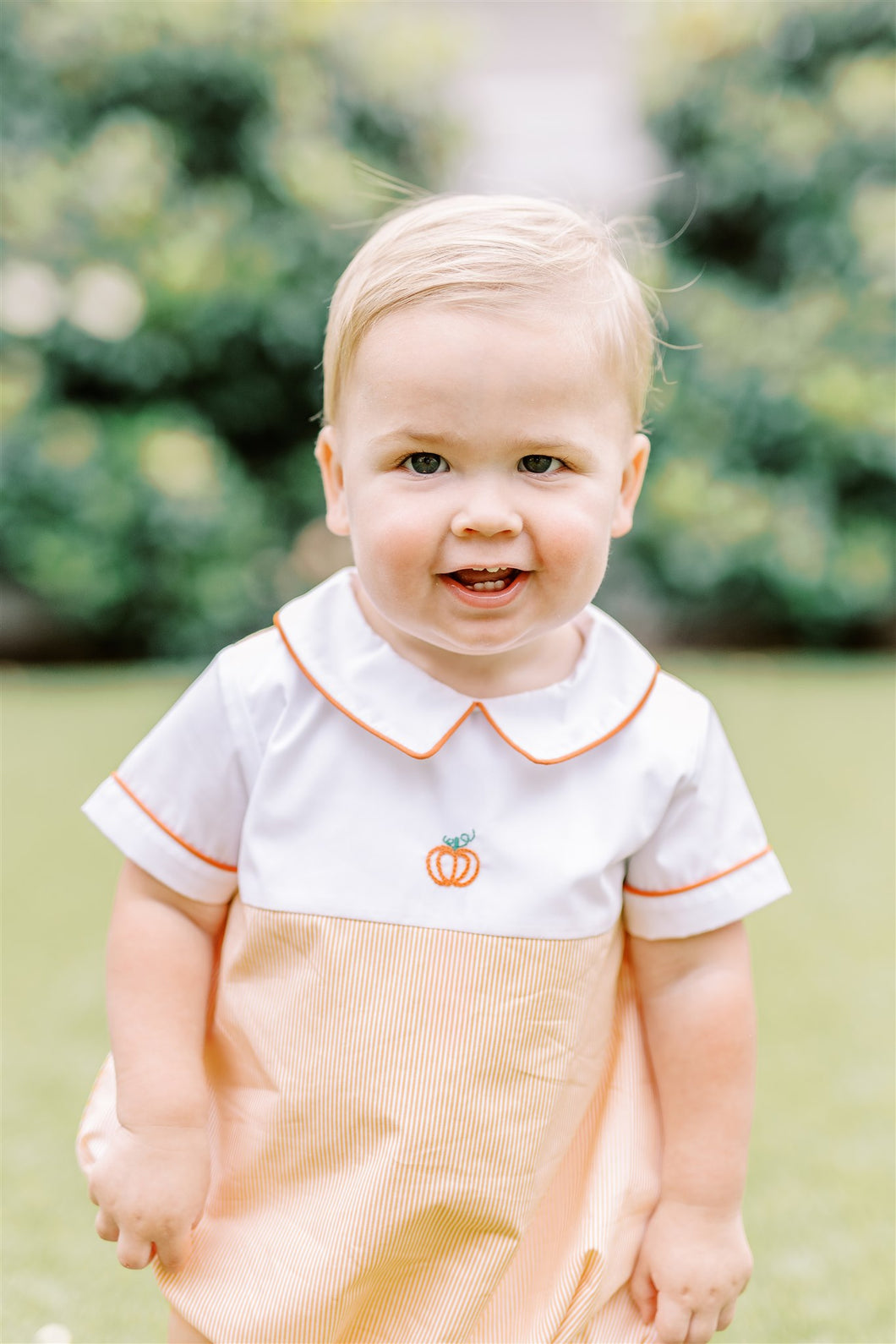 Dress your little one in festive charm with the Boys Pembroke Pumpkin Bubble from The Proper Peony. Featuring vibrant orange and white stripes, a crisp white peter pan collar, and a delicate embroidered pumpkin detail, this outfit combines playful style with seasonal spirit. Perfect for autumn celebrations, it offers both comfort and adorable appeal that will make your child stand out.