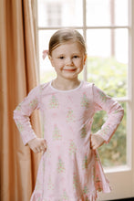 Load image into Gallery viewer, The Girls Pink Tinsel Twirl Playdress from The Proper Peony is made from soft knit fabric, featuring a charming pink background adorned with elegant Christmas trees decorated with pink ornaments and bows. This delightful dress combines comfort with festive style, making it perfect for everyday wear and holiday celebrations. Let her twirl into the season with excitement and joy in this beautifully designed playdress that captures the magic of the holidays.
