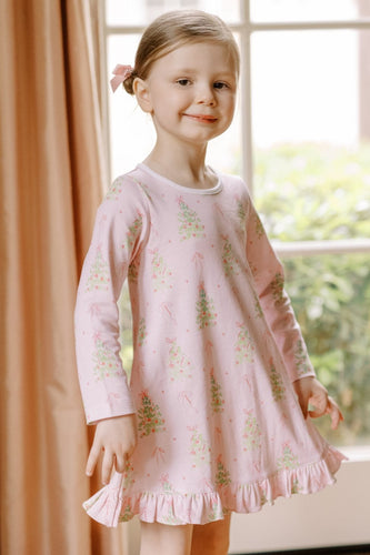 The Girls Pink Tinsel Twirl Playdress from The Proper Peony is made from soft knit fabric, featuring a charming pink background adorned with elegant Christmas trees decorated with pink ornaments and bows. This delightful dress combines comfort with festive style, making it perfect for everyday wear and holiday celebrations. Let her twirl into the season with excitement and joy in this beautifully designed playdress that captures the magic of the holidays.