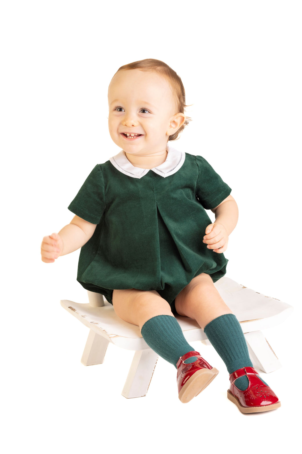 Elevate your little boy's festive wardrobe with the Boys Holly Jolly Velvet Bubble from Sophie & Lucas. Crafted from rich dark green velvet, this bubble features a charming white peter pan collar that adds timeless elegance. Perfect for holiday gatherings, it pairs beautifully with the Girl's Holly Jolly Velvet Miller Dress for coordinated family photos. Soft, stylish, and comfortable, this bubble is sure to make him the center of attention this season.
