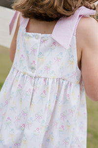 Indulge in the beauty of nature with Thea Flower Bouquet Dress from James &amp; Lottie! Adorned with floral bouquets and cute bows, this dress exudes a sense of elegance. The pink and white seersucker ties on the shoulders add a charming touch. Perfect for any occasion, this dress will make you feel like a blooming flower!
