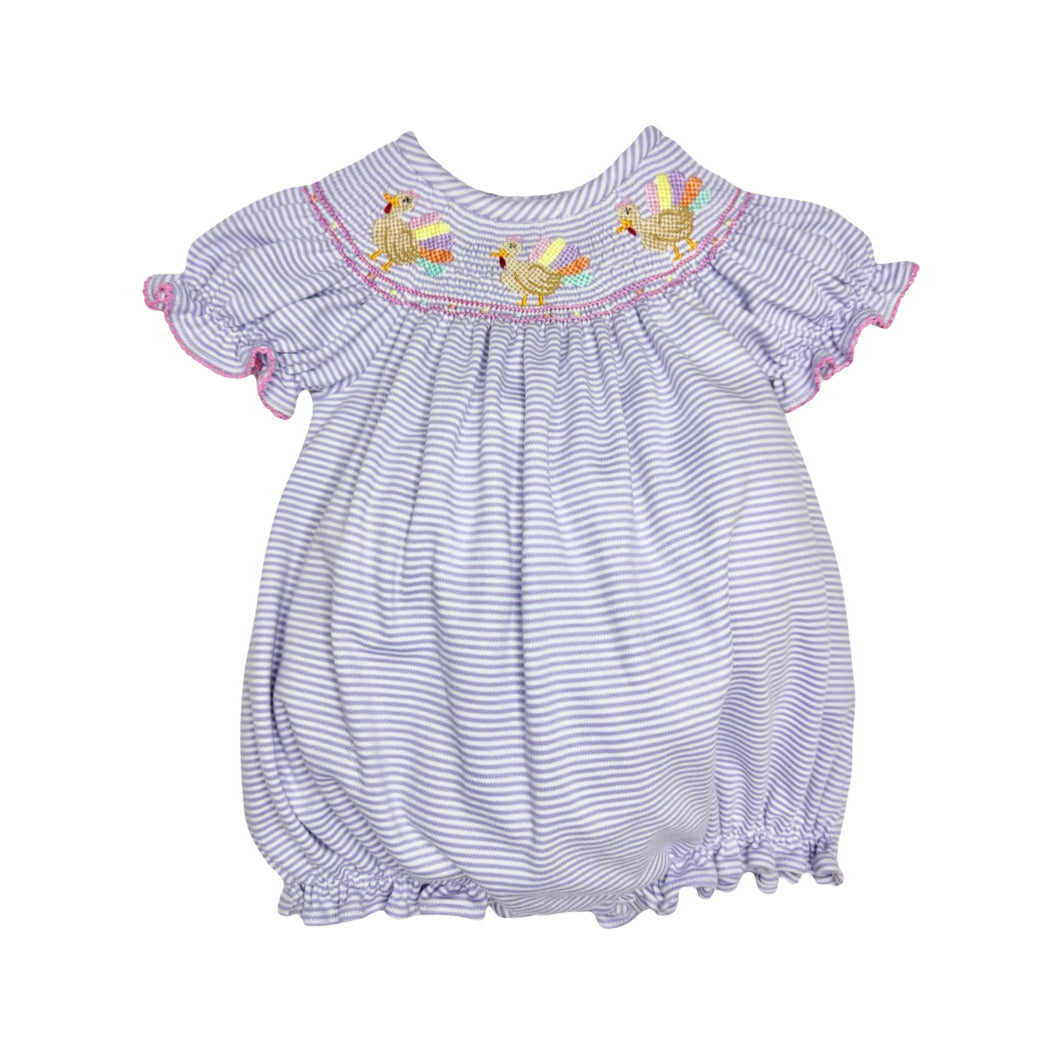 Dress your little one in playful charm with the Infant Girls Lavender Turkey Billie Bishop Bubble from Zuccini Kids. Soft lavender and white mini stripes create a gentle backdrop for the delightful smocked neckline, featuring colorful embroidered turkeys that add a whimsical touch. Comfortable and stylish, this bubble romper is perfect for keeping your infant cozy while standing out with unique, eye-catching details.