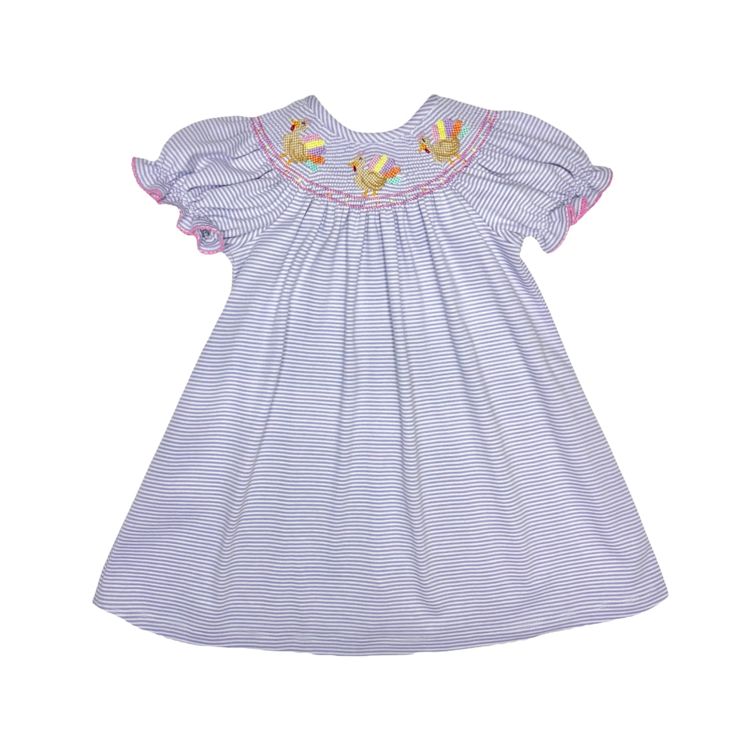 Celebrate Thanksgiving in style with the Girls Lavender Turkey Billie Bishop Dress from Zuccini Kids. This soft knit dress features charming lavender and white stripes and a delicate smocked neckline adorned with colorful embroidered turkeys. Comfortable and festive, it’s the perfect choice to make holiday moments memorable while keeping your little girl cozy and joyful.